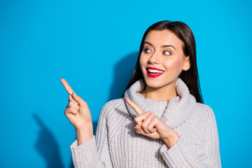 Fototapeta premium Photo of wondered lady indicating arms empty space wear warm knitted pullover isolated blue background
