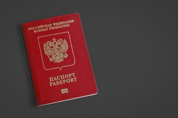 Russian foreign passport on a dark gray background. Dark red passport cover. Copy space