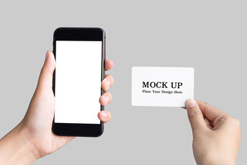 Fototapeta na wymiar two hands holding smart phones and empty white card on white background with clipping path
