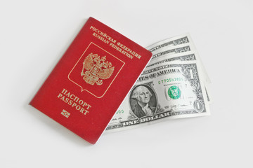 The Russian foreign passport  lies on top of one-dollar bills on a light background. Traveling abroad, budget vacation.
