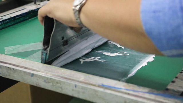 Hand pressing silk-screen printing, close up view.
