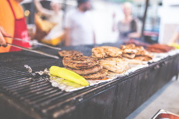 Man preparing burgers at street festival.