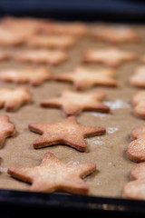Cooking cookies with cookie cutters on a dark table