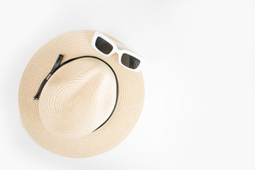 Beach sun hat with sunglasses top view on white background.
