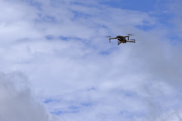Fototapeta na wymiar Black drone quadcopter flying on the air for take a photo and video with cloudy background.