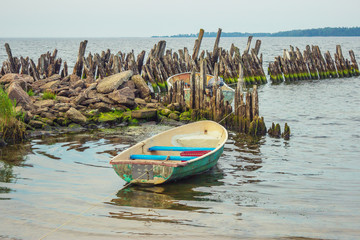 old fiberglass boat tied in shallow water