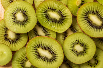 heap of fresh green kiwi slices background. top view