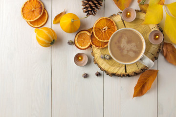 Hot autumn drink, coffee or cocoa, with yellow leaves and decorative pumpkins on a white wooden table. autumn composition. top view.