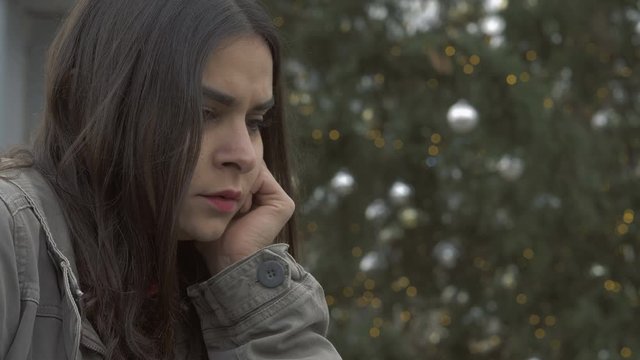 Depressed sad lonely young woman crying at christmas time-outdoor