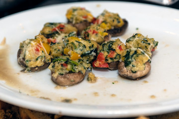 Melted cheese tops the stuffed mushroom caps as the plate of hors d'oeuvre goes round.