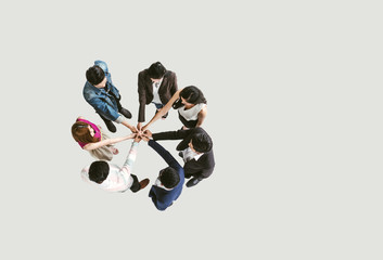 Top view of business people standing with their hands together in a huddle stack hand teamwork...