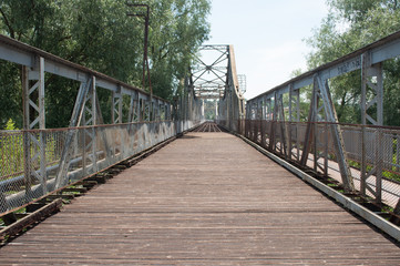 Fototapeta na wymiar Road through the steel bridge near the trees