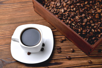 white coffee cup, morning side light coffee beans wooden box with coffee, top view natural wooden background