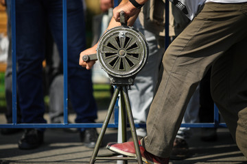 Shallow depth of field image with a man handling a vintage hand crank air raid siren