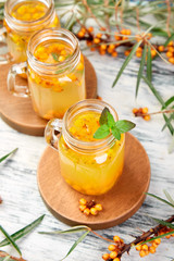 Hot sea buckthorn tea with ginger and honey and sea buckthorn berries on white table. Top view. Vitaminic healthy.