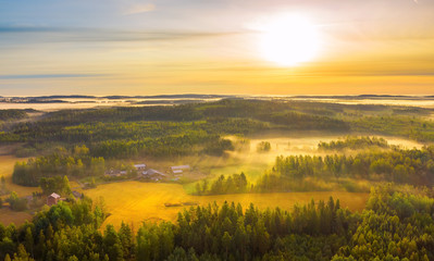 Fototapeta na wymiar Aerial view of Pulkkilanharju Ridge, Paijanne National Park, southern part of Lake Paijanne. Landscape with drone. Fields, houses and green forests from above on a sunrise summer day in Finland.