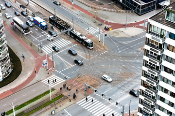 Busy cross road from above in a downtown, pedestrians in a zebra, metro stoped and cars passing by. 