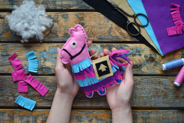 Making pink lama. Sewing toys from felt with your own hands. DIY concept for children. Handmade crafts. Step 6. Finished toy. © Oksana_S