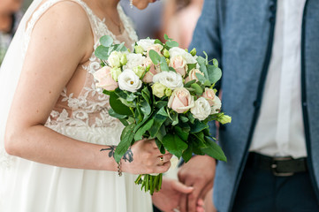 Obraz na płótnie Canvas White flowers in the hand of the bride