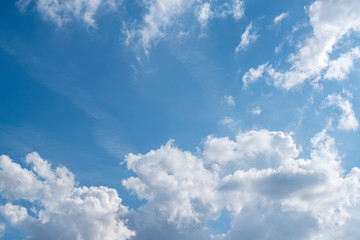 Naklejka na ściany i meble Fluffy clouds against a blue sky. Natural background.