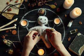 In Voodoo doll are needles pricked. Candles, pentagram, stones, love potion and old books on witch...