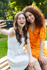 Two cheerful young girls friends spending time outdoors