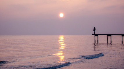 Silhouette person standing on pier in sunset, southern sweden