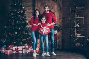 Full length body size view of three nice attractive lovely careful cheerful cheery family mom dad holding in hands purchase celebrating newyear in decorated industrial loft wood brick style interior