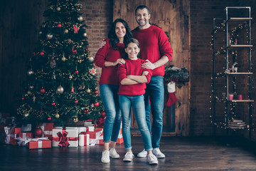 Full length body size view of three nice attractive lovely cheerful cheery family enjoying christmastime mom dad in decorated industrial loft wood brick style interior indoors