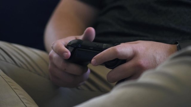 Close up shot of a guy playing video game console.