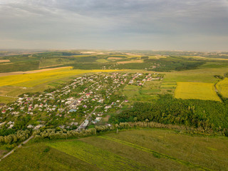 Fototapeta premium Aerial view over a small village and agricultural fields