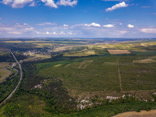 Fototapeta na wymiar Aerial view of a provincial road passing through a forest and green lands