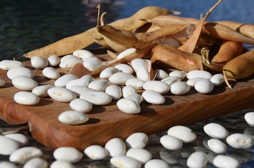 White beans and beans in the pod on a wooden board and on a glass table.nutrition. food. eco-products in farm. Organic. Vegetarian. Health life