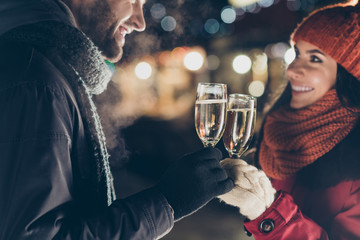 Close-up cropped portrait of his he her she nice attractive lovely charming cheerful cheery couple wearing warm outfit holding in hands glasses congratulating outdoors spending vacation