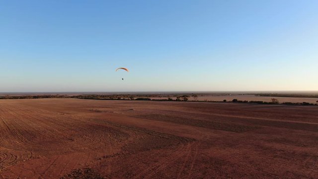 Paramotor flying in summer day at Granite Field South Australia.