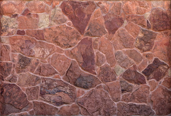 Old abandoned vintage wall made of natural red textured spotted stone and concrete. Abstract trendy creative background
