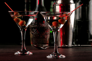 Martini. Alcoholic drink martini with olives in a glass on a dark background in the bar on the bar counter. bar inventory. cocktails