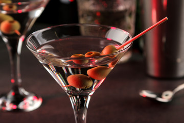 Martini. Alcoholic drink martini with olives in a glass on a dark background in the bar on the bar counter. bar inventory. cocktails