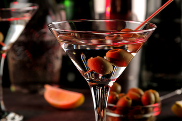 Martini. Alcoholic drink martini with olives in a glass on a dark background in the bar on the bar counter. bar inventory. cocktails