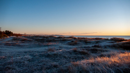 Fototapeta na wymiar crispy winter sunset over the sea and land