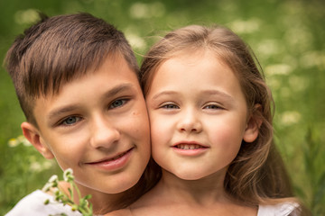  close-up portrait of brother and sister outdoors in summer