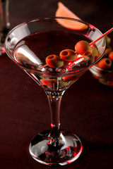 Martini. Alcoholic drink martini with olives in a glass on a dark background in the bar on the bar counter. bar inventory. cocktails