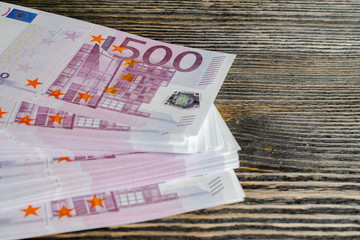 bundle of expensive Euro banknotes on a wooden background