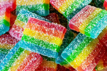 a bunch of gummy rainbow candy in sugar closeup