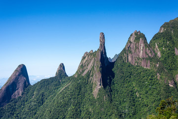 Postcard trail view where you can observe in detail de vegetation and topography of the to Serra dos Orgãos (Organs Mountain) with Finger's God highlighted in landscape.