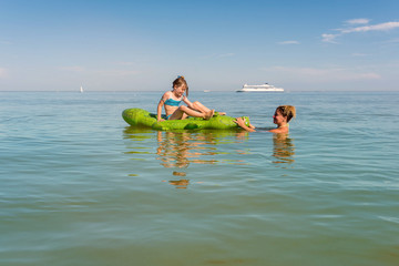 maman et sa fille jouant dans la mer