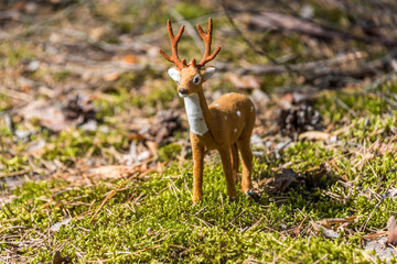 Little Toy Deer in a Green Forest on a Sunny Day