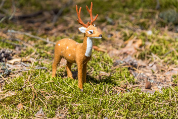 Little Toy Deer in a Green Forest on a Sunny Day