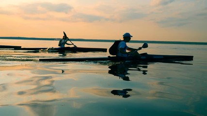 Group of paddlers are canoeing along the lake