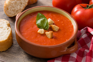 Tomato soup in brown bowl on wooden table